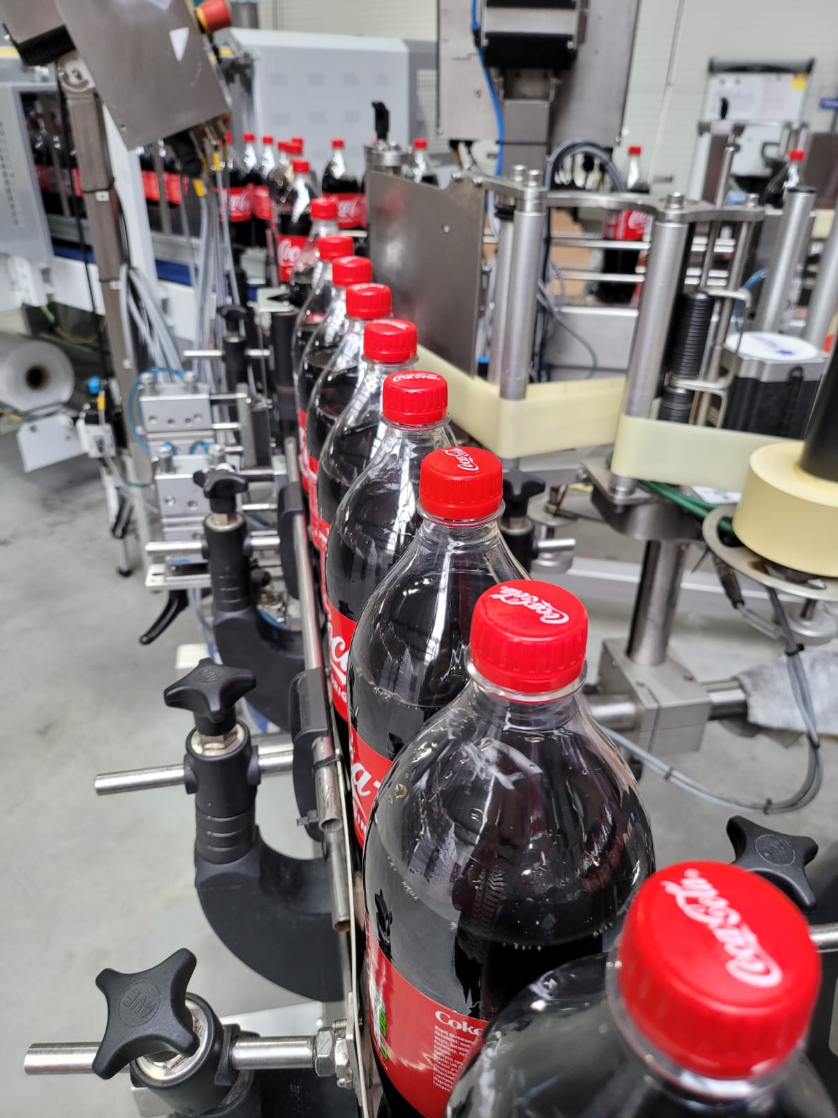 1.5L bottles Polish Coca Cola during machine labeling